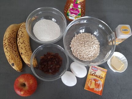 Ingrediënten voor havermout muffins met banaan, appel en rozijnen.