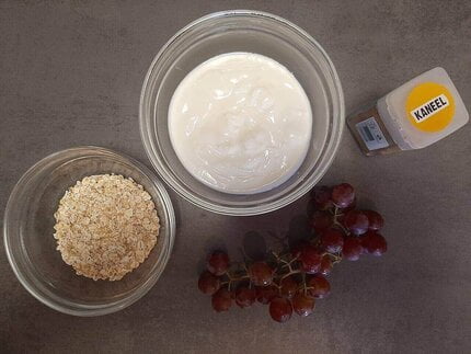 De ingrediënten voor yoghurt met havermout, druiven en kaneel.